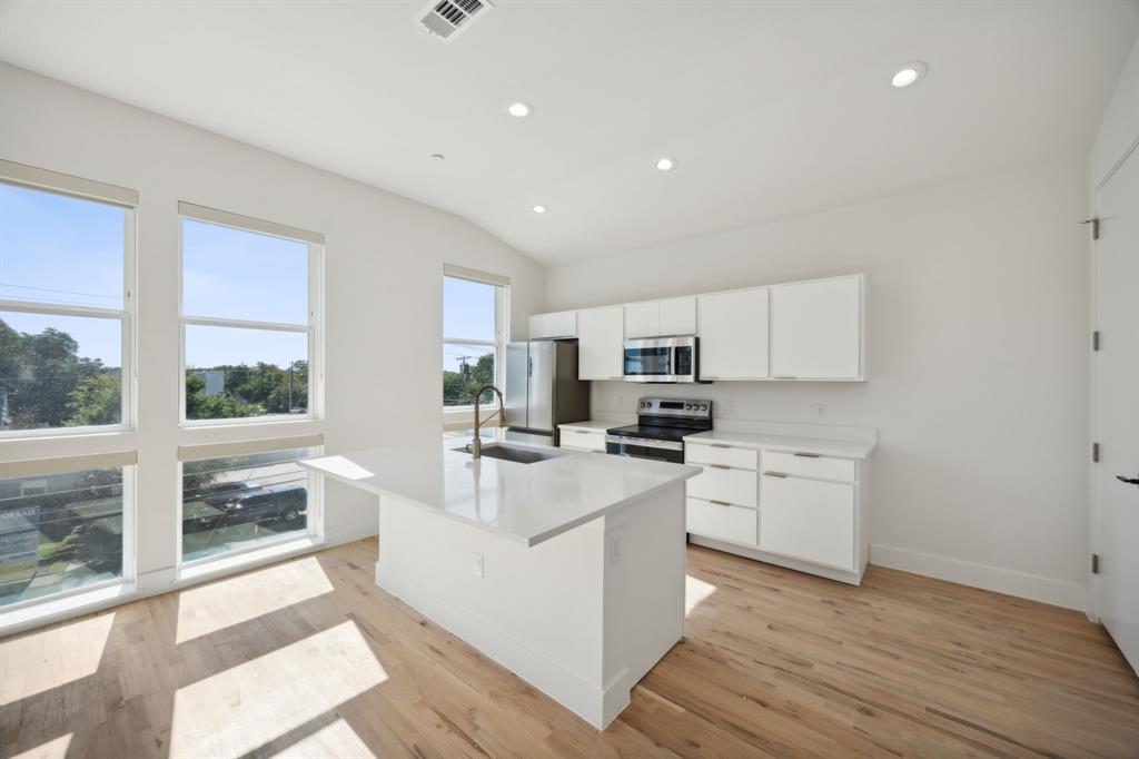 4907 Bryan Street Dallas, TX 75204 - Photo 18 of 21 a living room with stainless steel appliances furniture a large window and a kitchen view