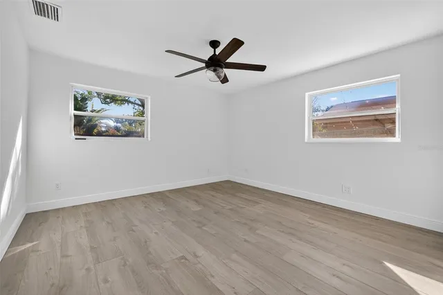 a view of empty room with wooden floor