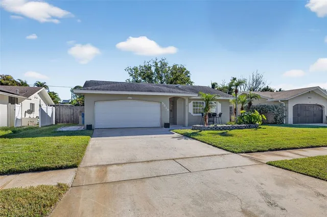 a view of a house with a yard and a garage