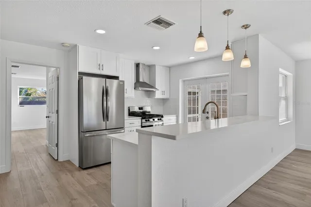 a kitchen with stainless steel appliances a refrigerator and a stove top oven