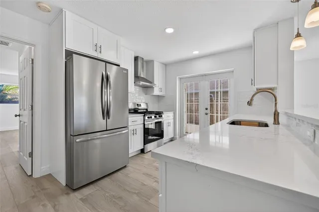 a kitchen with a refrigerator a stove and a sink with wooden floor