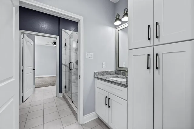 a bathroom with a granite countertop sink a mirror and a shower