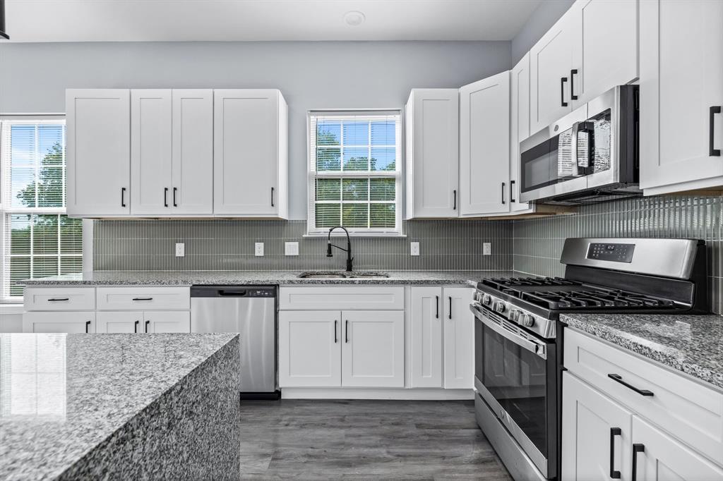 1701 Belzise Terrace Fort Worth, TX 76104 - Photo 19 of 35 a kitchen with stainless steel appliances granite countertop a stove sink and cabinets
