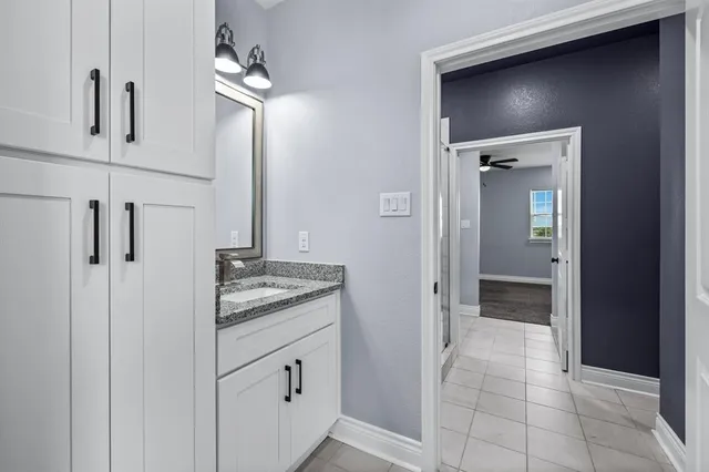 a bathroom with a granite countertop sink a mirror and a vanity