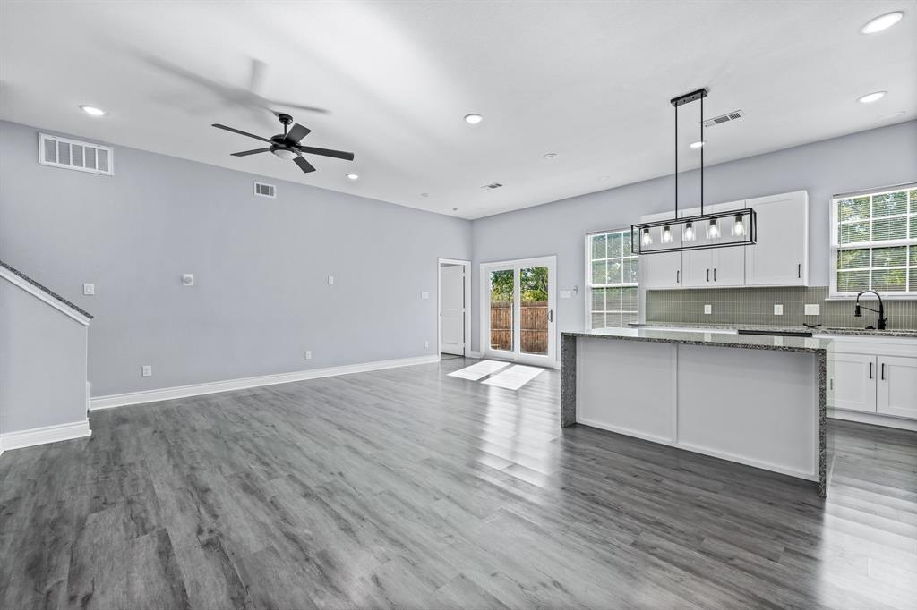 1701 Belzise Terrace Fort Worth, TX 76104 - Photo 28 of 35 a kitchen with kitchen island granite countertop a sink cabinets and wooden floor