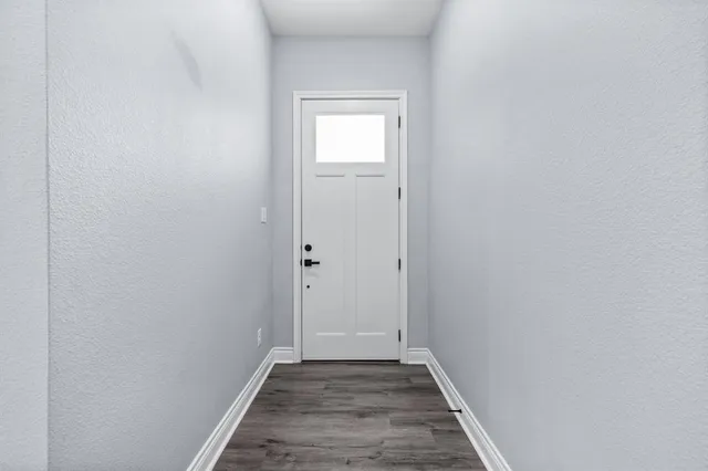 a view of a hallway with wooden floor