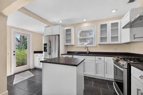 a kitchen with stainless steel appliances granite countertop a stove a sink and a refrigerator