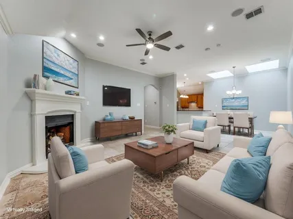 a view of an empty room with window and chandelier fan