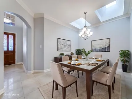 a view of a livingroom with a chandelier fan and kitchen view