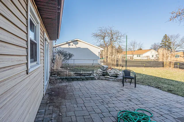 a view of a patio with table and chairs with wooden floor and fence