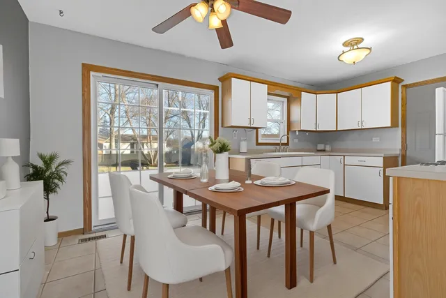 a kitchen with a table chairs sink and cabinets