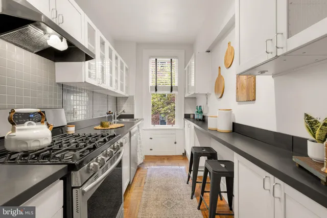 a kitchen with stainless steel appliances granite countertop a sink stove and cabinets