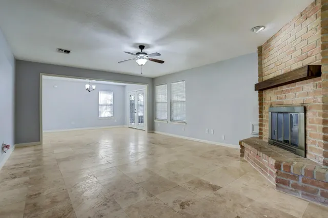 a view of an empty room with a fireplace and a window