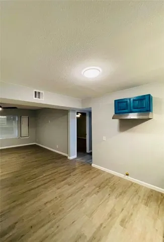 an empty room with a ceiling fan and wooden floor