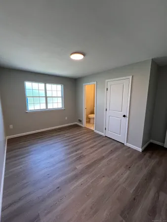 an empty room with wooden floor and window
