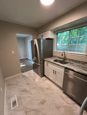 a kitchen with stainless steel appliances kitchen island granite countertop a sink stove and refrigerator