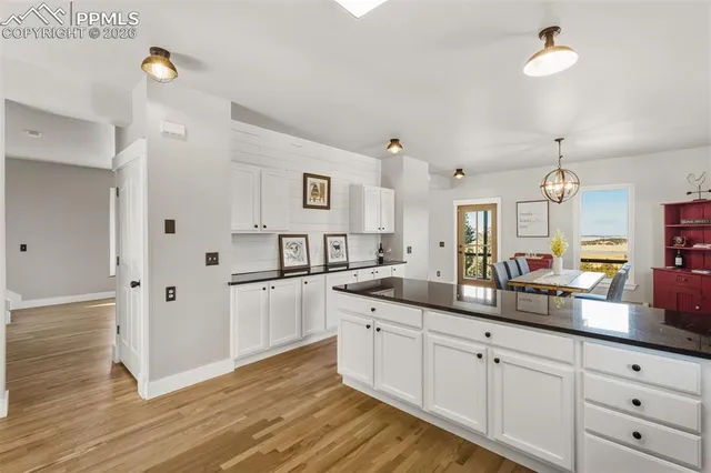 a kitchen with white cabinets and sink