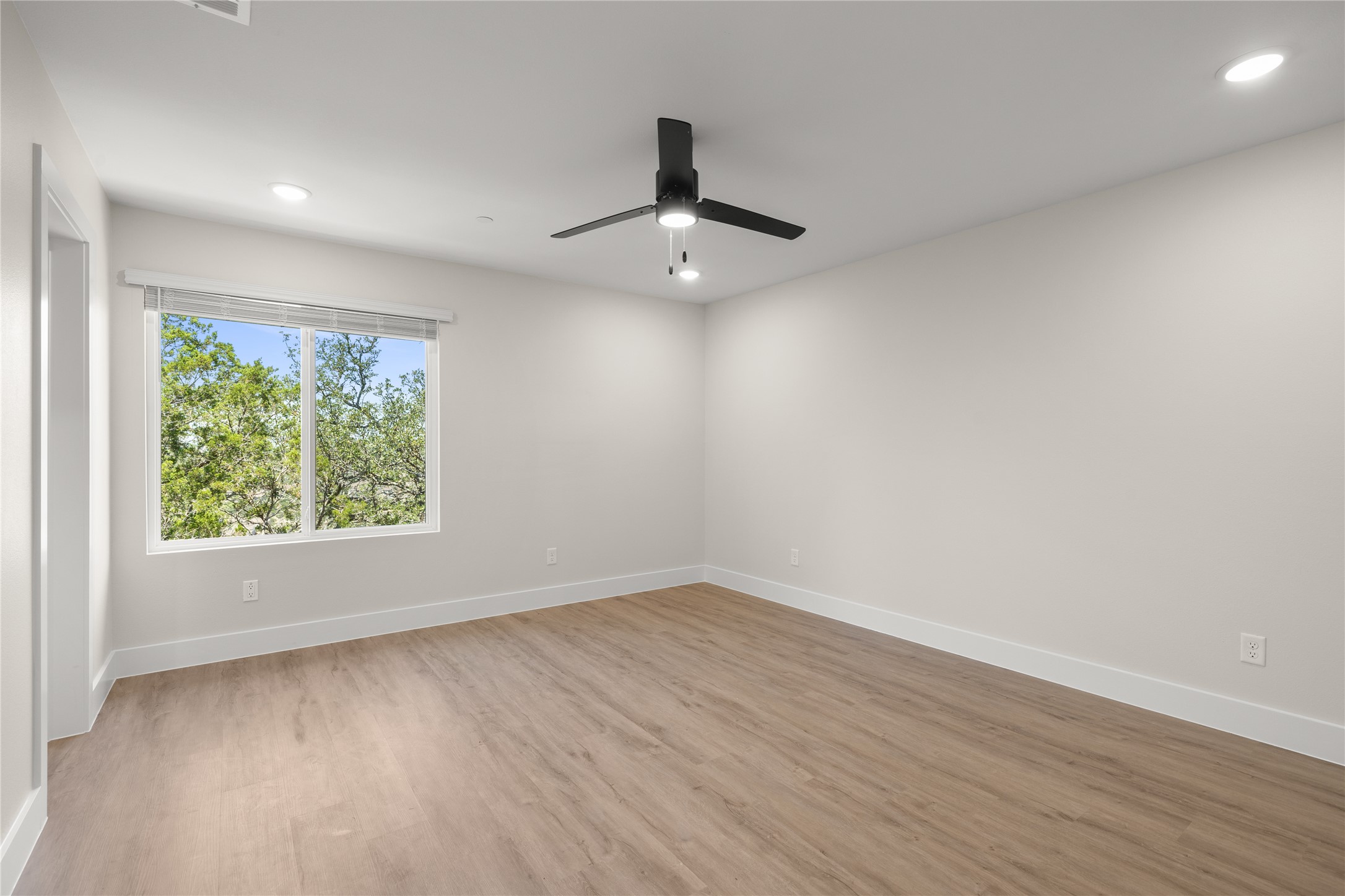 5514 Mobeetie Loop Bee Cave, TX 78738 - Photo 10 of 20 a view of an empty room with wooden floor and a window