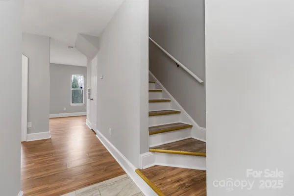 a view of a hallway with wooden floor and entryway