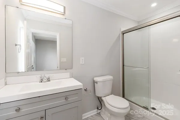 a bathroom with a sink a toilet a shower and a mirror