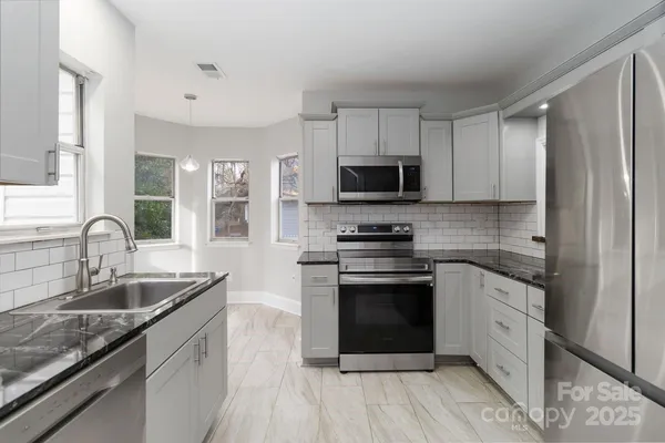 a kitchen with stainless steel appliances granite countertop a sink stove and refrigerator