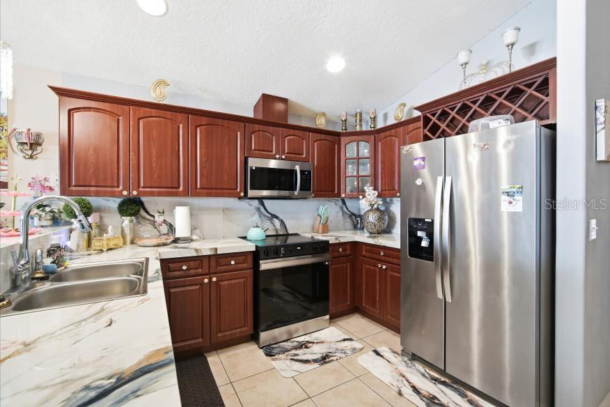 3005 West Chestnut Street Tampa, FL 33607 - Photo 9 of 27 a kitchen with stainless steel appliances granite countertop a refrigerator and a stove top oven