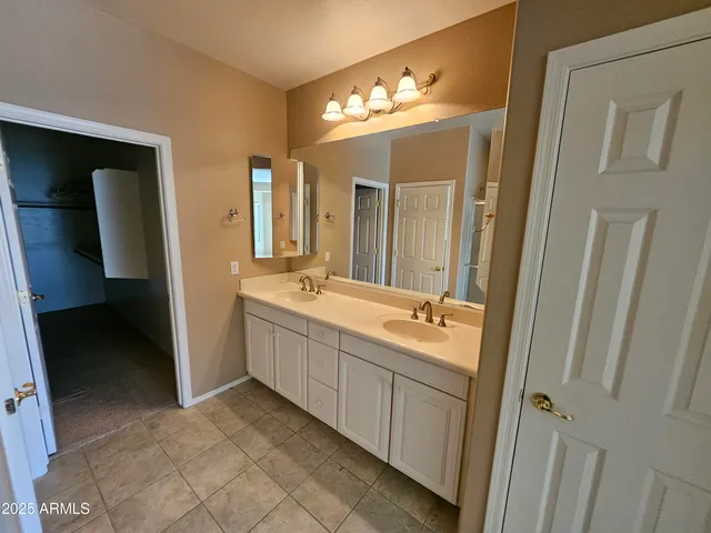 a bathroom with a double vanity sink mirror and toilet