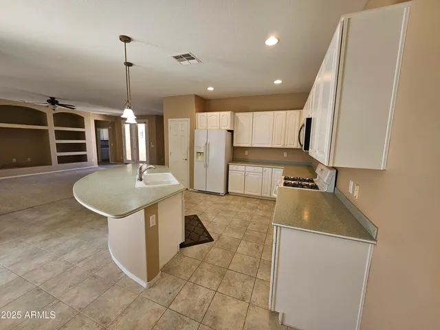 a kitchen with a sink a counter top space appliances and cabinets