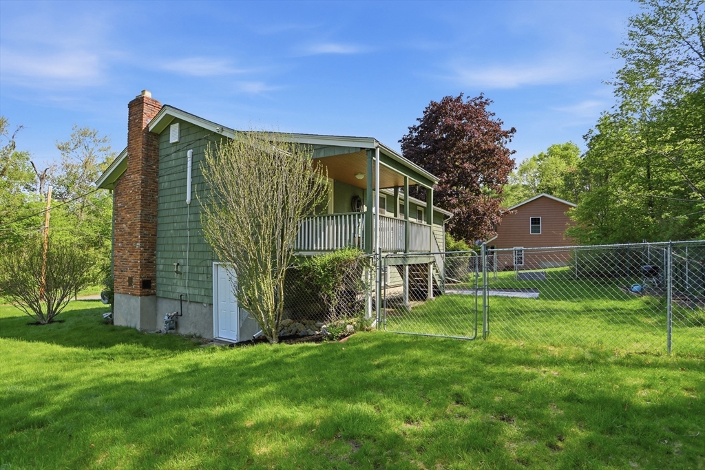 33 Simon Willard Road Acton, MA 01720 - Photo 36 of 42 a backyard of a house with plants and wooden fence