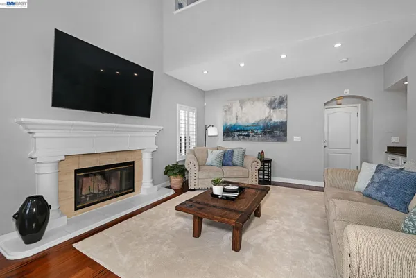 a living room with furniture a flat screen tv and a fireplace