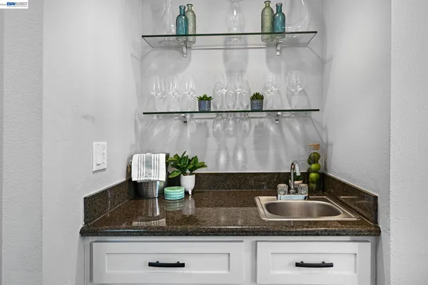 a bathroom with a granite countertop sink a mirror and vanity