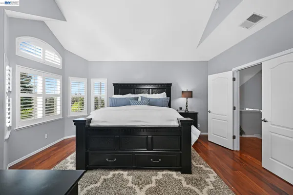a bedroom with a bed and a large window