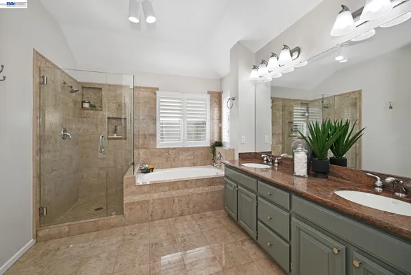a spacious bathroom with a tub shower sink and mirror