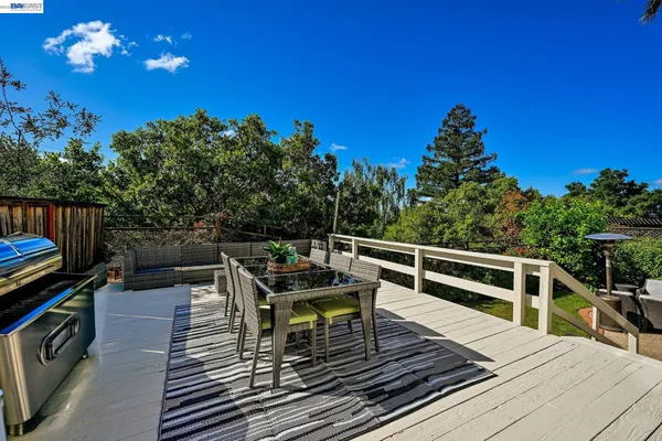 a view of a roof deck with dining table and chairs with wooden floor
