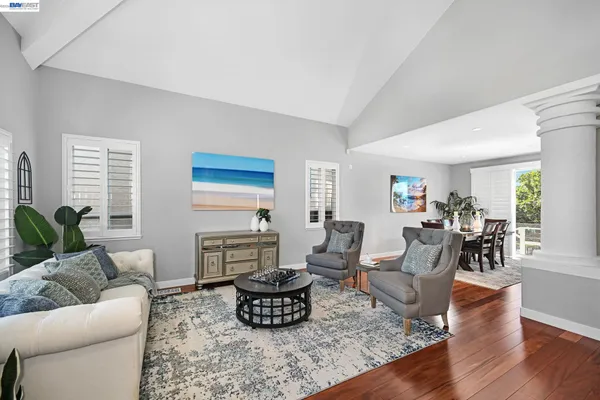 a living room with furniture a wooden floor and a large window