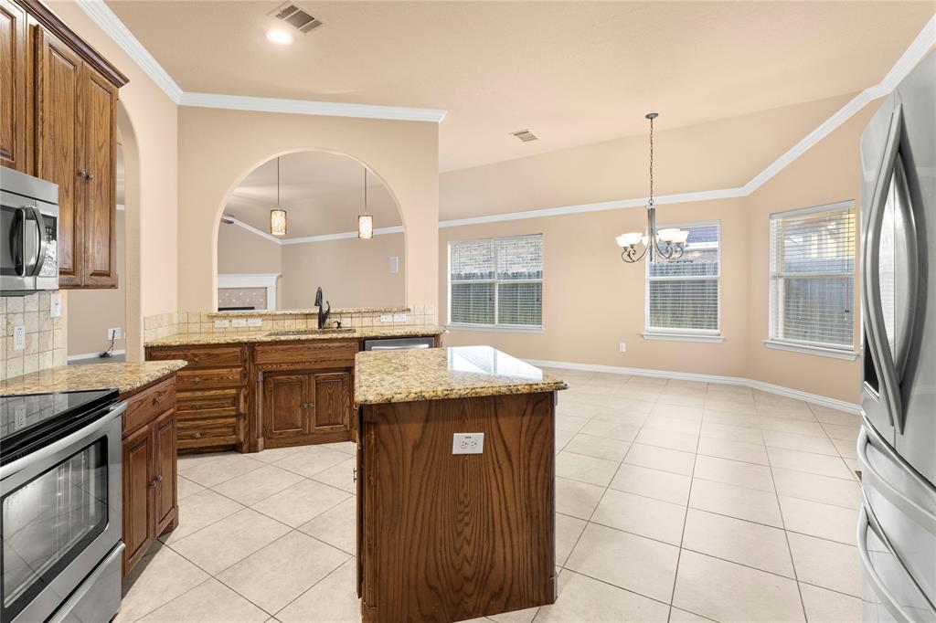 8245 Edgepoint Trail Fort Worth, TX 76053 - Photo 15 of 28 a kitchen with granite countertop a stove a sink and a refrigerator