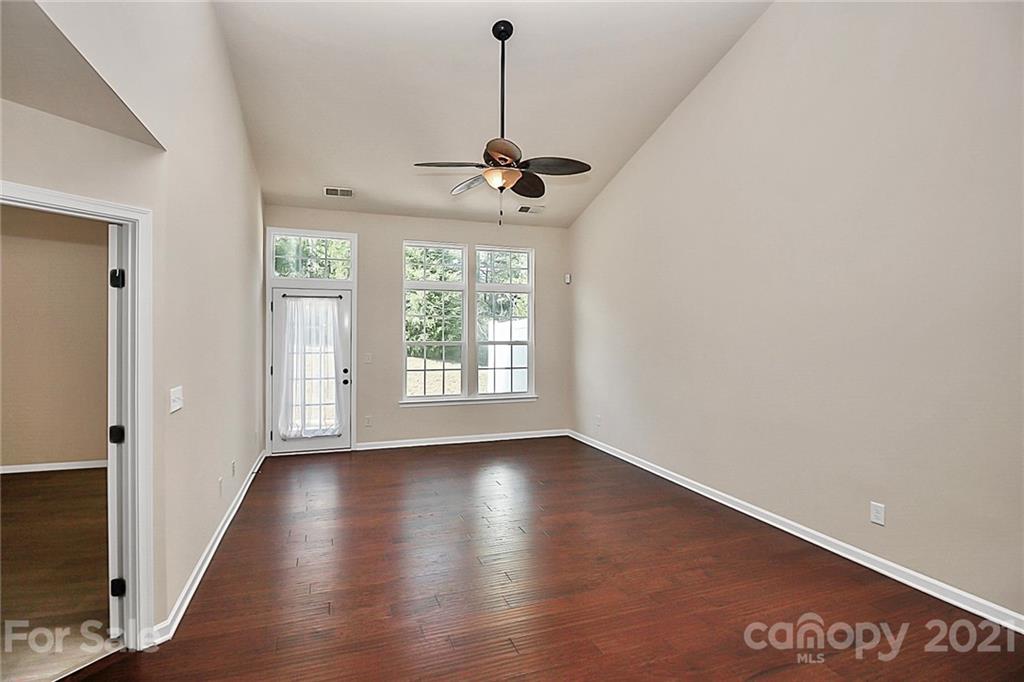 109 Inlet Point Drive Tega Cay, SC 29708 - Photo 15 of 48 an empty room with wooden floor chandelier fan and windows