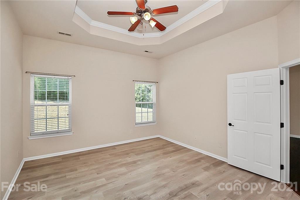 109 Inlet Point Drive Tega Cay, SC 29708 - Photo 17 of 48 an empty room with wooden floor chandelier fan and windows