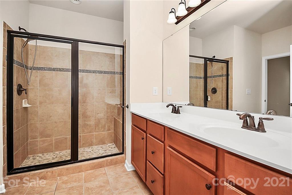 109 Inlet Point Drive Tega Cay, SC 29708 - Photo 19 of 48 a bathroom with a double vanity sink and a mirror