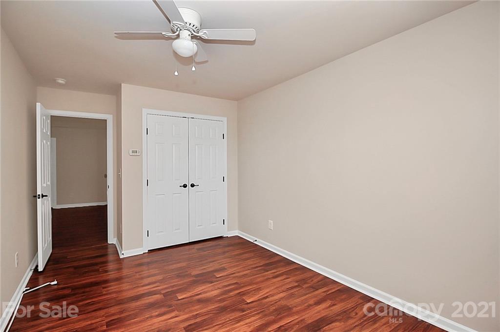 109 Inlet Point Drive Tega Cay, SC 29708 - Photo 29 of 48 an empty room with wooden floor a ceiling fan and closet