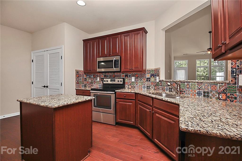 109 Inlet Point Drive Tega Cay, SC 29708 - Photo 6 of 48 a kitchen with stainless steel appliances granite countertop a stove sink and cabinets