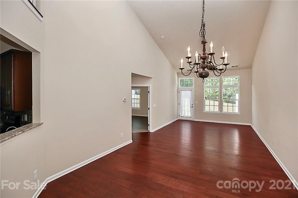 109 Inlet Point Drive Tega Cay, SC 29708 - Photo 10 of 48 a view of an empty room with a window and wooden floor
