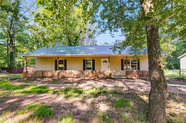 a view of a house with backyard and trees