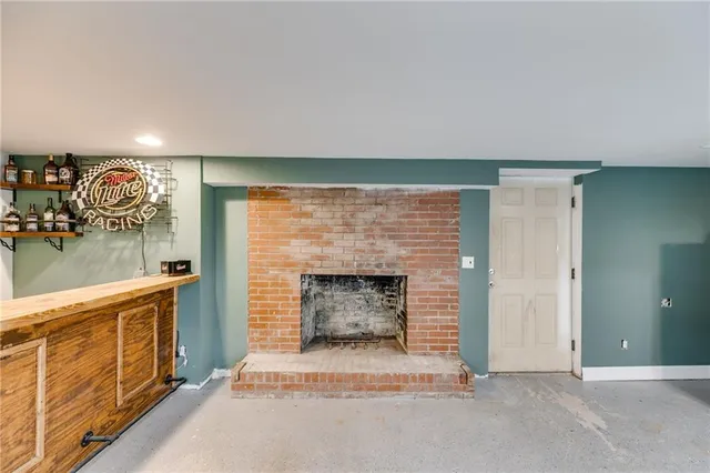 an empty room with fireplace and fan