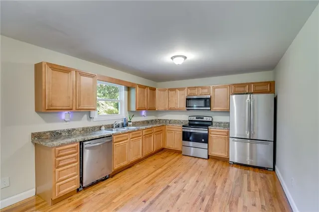 a kitchen with wooden floors and stainless steel appliances