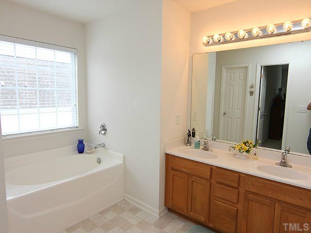 5317 Daleview Drive Raleigh, NC 27610 - Photo 10 of 14 a bathroom with a tub sink double and mirror