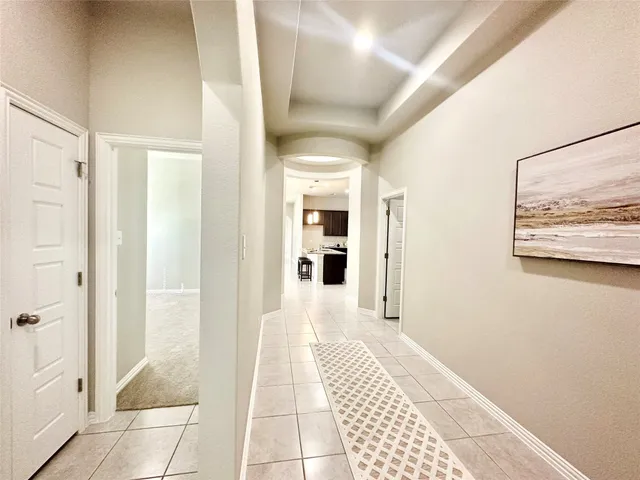 a view of a hallway with wooden floor and a bathroom