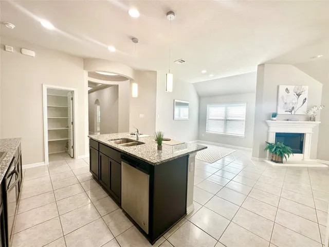 a large white kitchen with lots of counter top space and living room