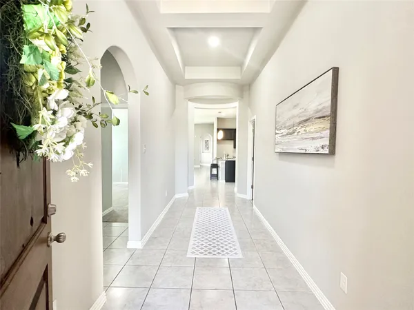 a hallway with painting and a potted plant