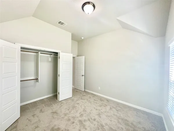 an empty room with closet and windows